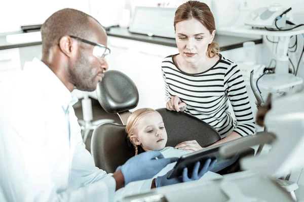 Досвідчений стоматолог використовує планшет для кращої демонстрації — стокове фото