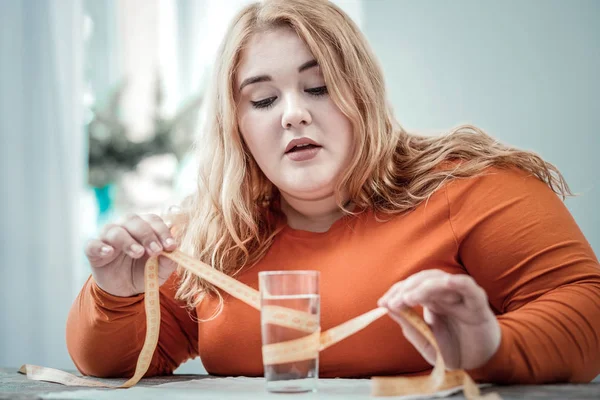 水のガラスを見て気配りふっくらした女の子 — ストック写真