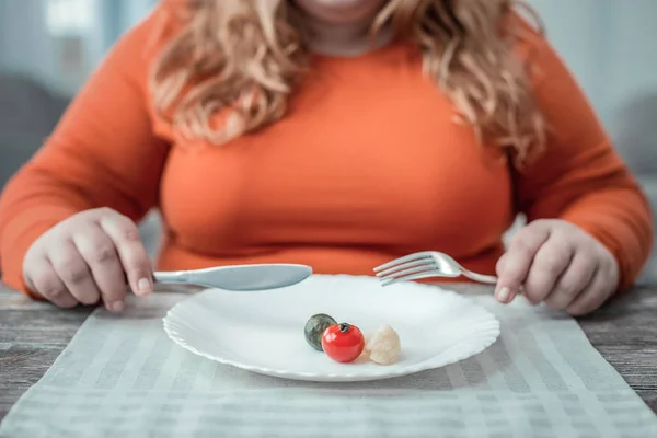 Overgewicht jonge vrouw eten van verse groenten voor het diner — Stockfoto