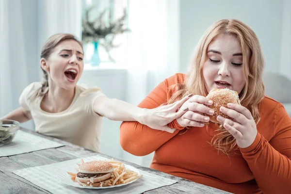 Positivo femmina paffuto felice andando a mangiare hamburger — Foto Stock