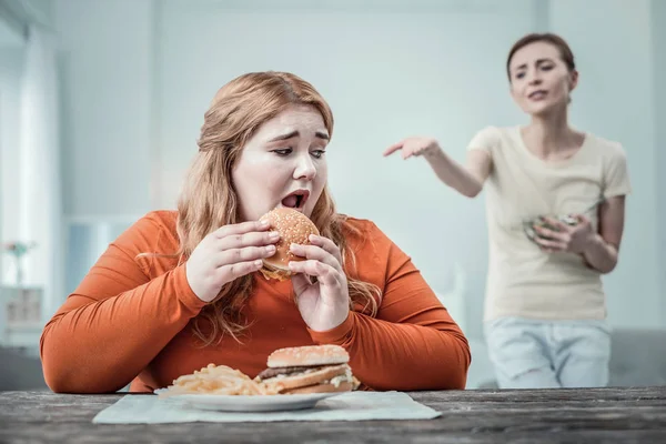 Chica emocional que tiene miedo de comer comida rápida — Foto de Stock