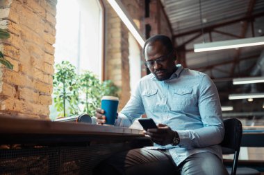 İç tasarımcı pencere yakınında oturan kahve molası olan