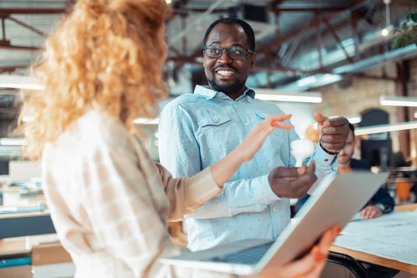 Diseñador de interiores radiante hablando con asistente rizado — Foto de Stock