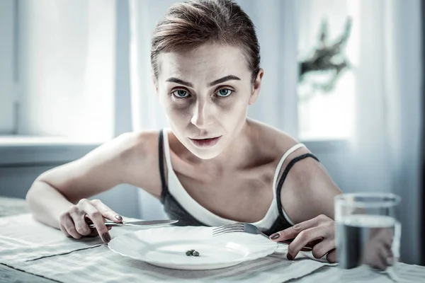 Unhealthy young woman looking straight at camera