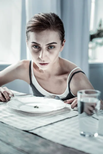 Anorexic vrouwelijke persoon droomt van vlees voor het diner — Stockfoto