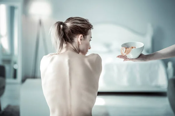 Attentive female person looking at white bowl — Stock Photo, Image