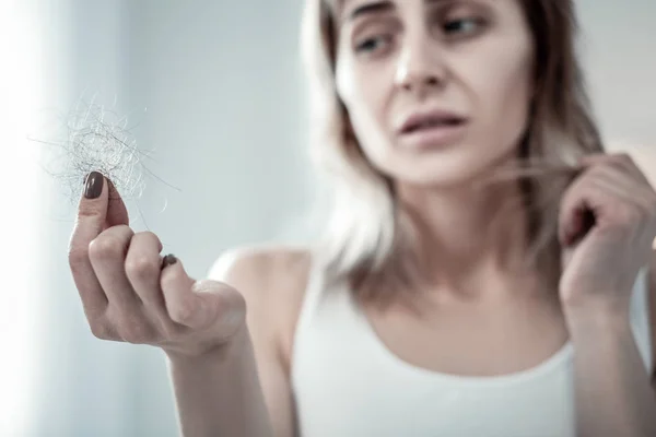 Focused photo on female hand that showing hair — Stock Photo, Image