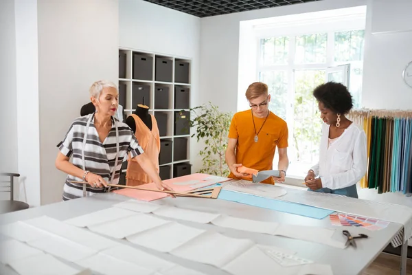 Elegante sastre femenino con una regla en la mano — Foto de Stock