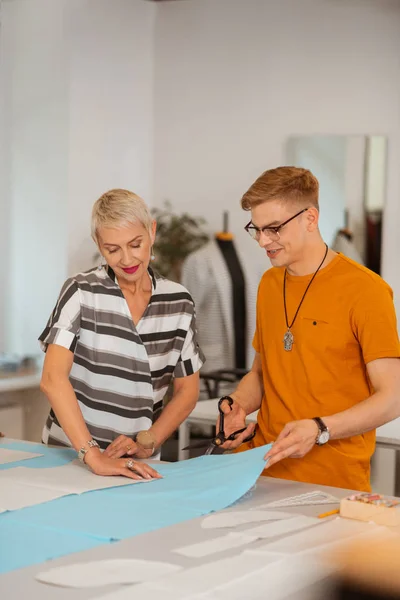 Lachende Senior aantrekkelijke vrouw drukken op het papieren patroon — Stockfoto