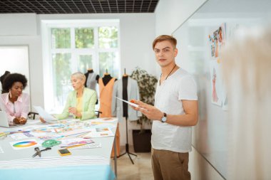Elinde bir kroki tutan yakışıklı tasarımcı
