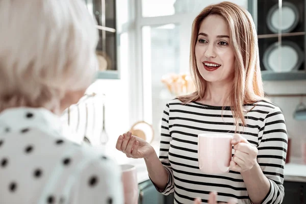 Beautiful woman smiling and looking at her mother while talking — Stock Photo, Image