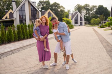 Mutlu olumlu anne ellerini çocuklarını tutarak