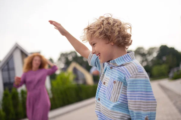 Mooie gelukkige blonde jongen die zijn hand omhoog houdt — Stockfoto