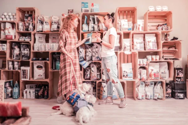 Σγουρά κοκκινομάλλα γυναίκα με δύο σκυλιά έρχονται σε κατοικίδιο ζώο κατάστημα — Φωτογραφία Αρχείου