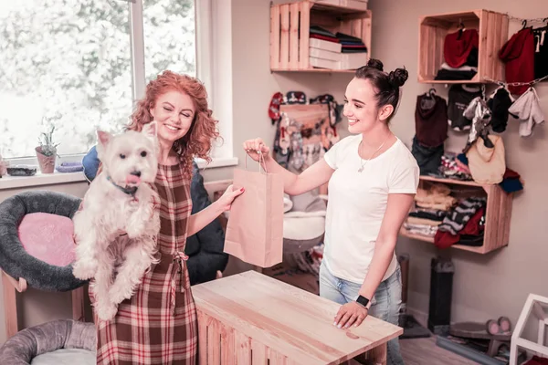 Mujer pelirroja rizada sintiéndose feliz después de comprar en la tienda de mascotas —  Fotos de Stock