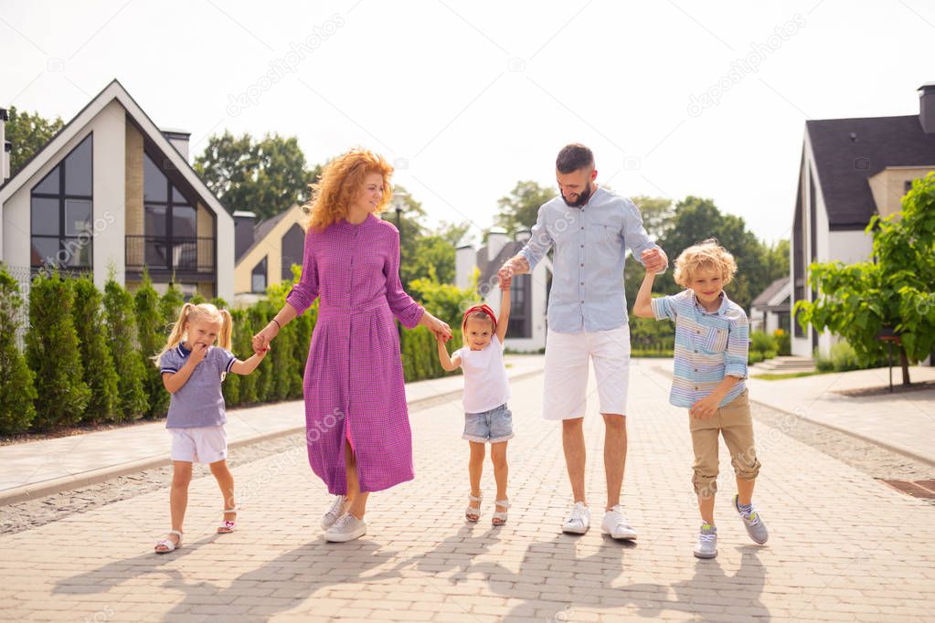 Delighted joyful family showing their unity to you