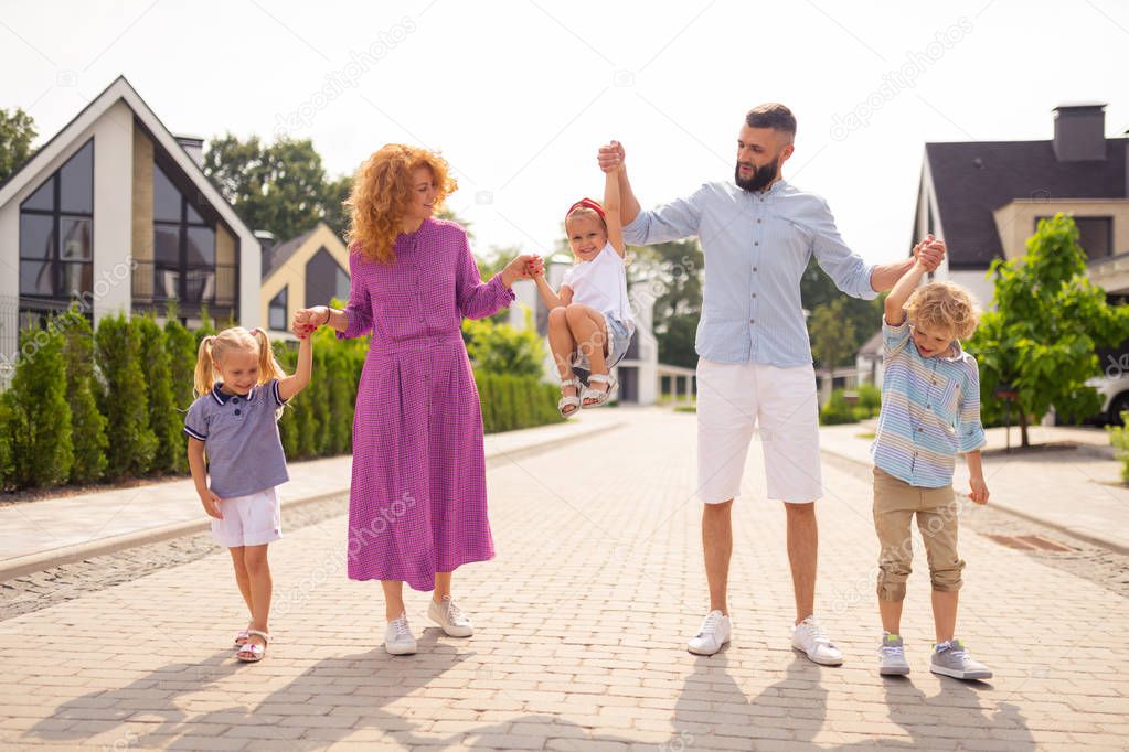 Positive cheerful family holding each others hands