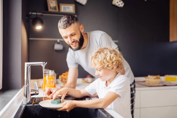 Fröhlicher netter Junge, der in der Nähe des Waschbeckens steht — Stockfoto