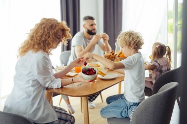 Sevimli sarışın çocuk kase bir çilek alarak