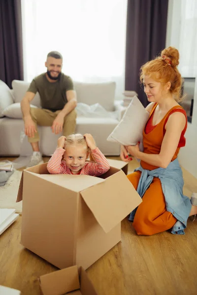 Delighted nice girl trying to hide in the box — Stock Photo, Image