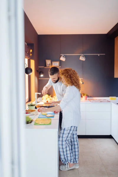 Позитивна подружня пара робить бутерброди на кухні — стокове фото