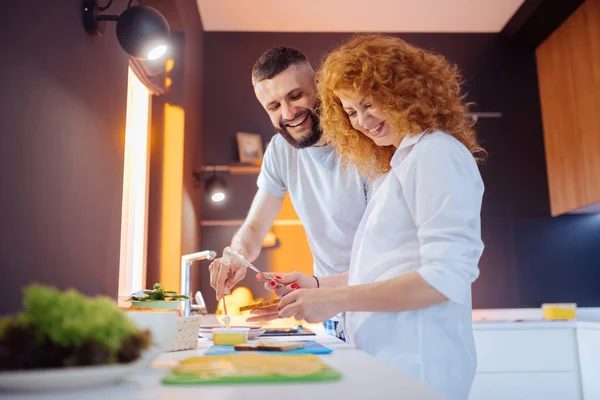 Šťastný pár připravuje sendviče v kuchyni — Stock fotografie