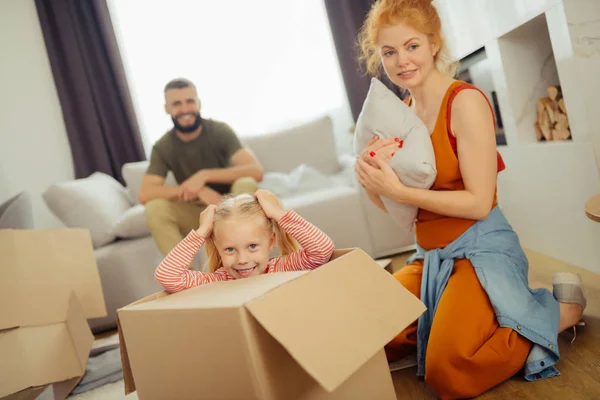 Cheerful positive girl sitting inside the box — Stock Photo, Image