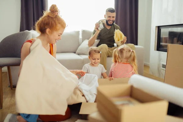 Delighted nice family unpacking their boxes together — Stock Photo, Image