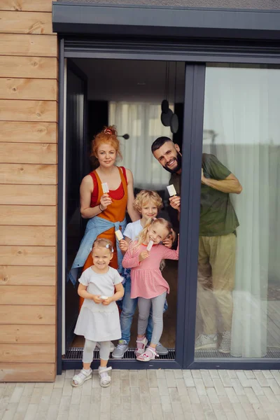 Vrolijke leuke familie staat voor de deur — Stockfoto