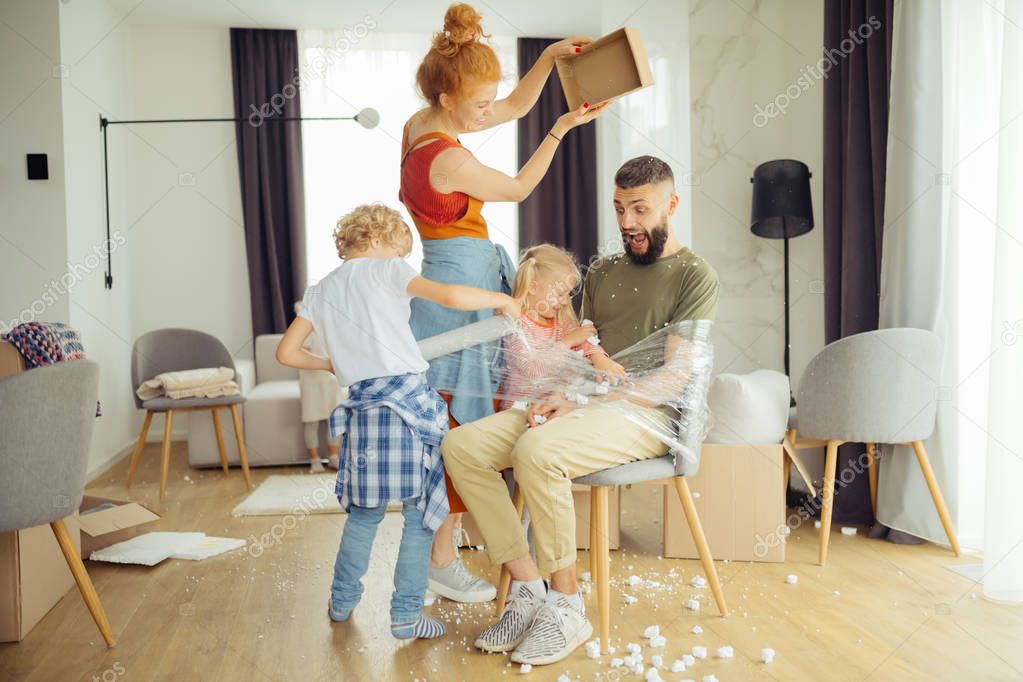 Nice happy kids tying up their father