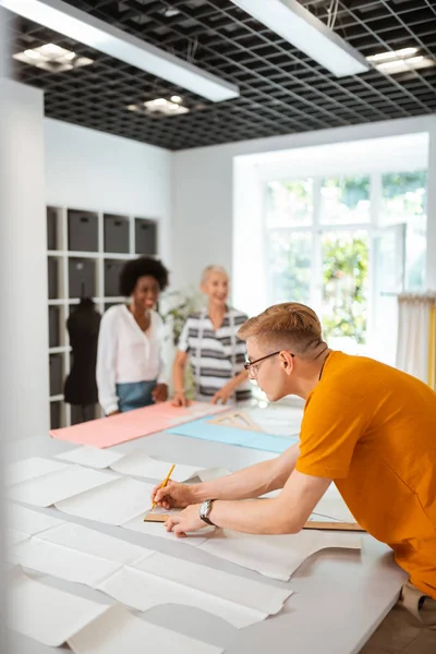 Jonge mannelijke modeontwerper werken in een studio — Stockfoto