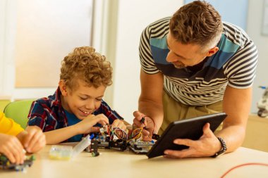 Öğretici ile bir tablet tutan Hoş güzel adam