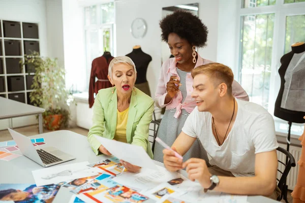 Motivated fashion designers sitting at a cutting table