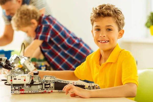 Bel ragazzo gioioso che ti mostra il suo lavoro — Foto Stock