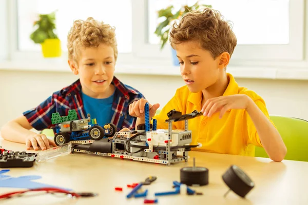 Agradáveis meninos bonitos sentados juntos na mesa — Fotografia de Stock