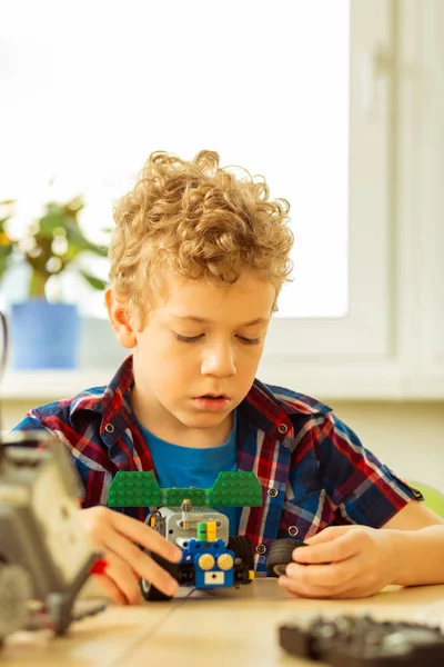 Smart trevlig pojke lära sig att konstruera en bil — Stockfoto