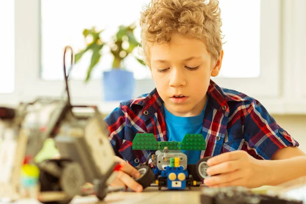 Bom menino loiro segurando rodas de brinquedo em suas mãos — Fotografia de Stock