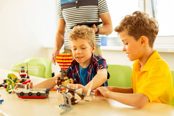 Feliz agradable jóvenes chicos construyendo juguetes juntos —  Fotos de Stock