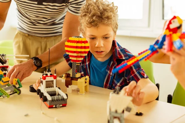 Aranyos szőke fiú van elfoglalva, játékok építése — Stock Fotó