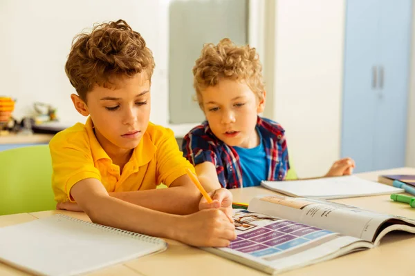 Nice young boys sitting at one desk — Stock Photo, Image