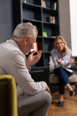 Erkek gesticulating ve sarışın bir kadın konuşuyor