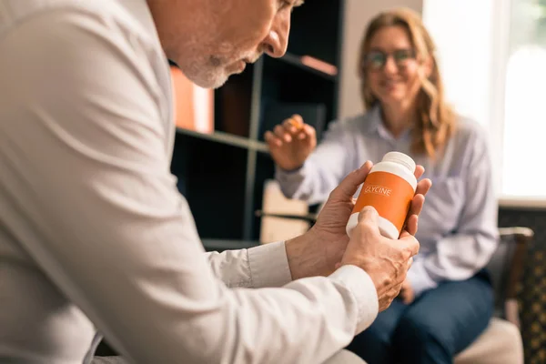 Hombre serio sosteniendo drogas soporíferas en sus manos — Foto de Stock