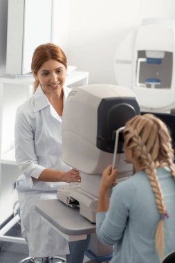 Oftalmolog genç kız danışmanlık yaparken neşeli hissediyorum