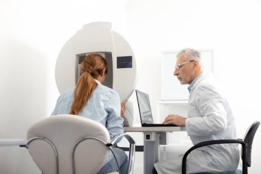 Deneyimli gri saçlı göz uzmanı danışmanlık kızıl saçlı kadın