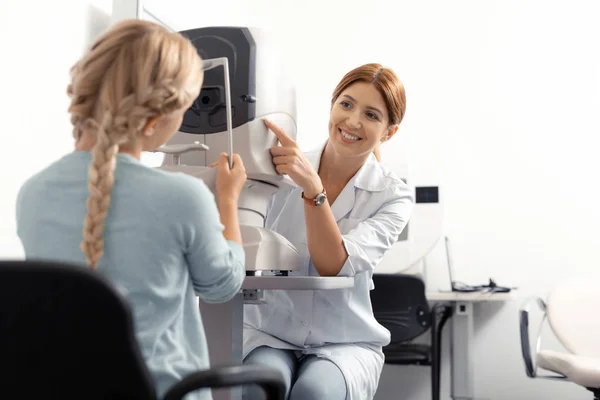 Око лікаря посміхається під час перевірки зору дівчини-підлітка — стокове фото