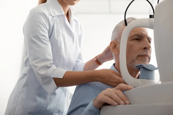 Офтальмолог стоит рядом с пациентом, наблюдая за зрением — стоковое фото