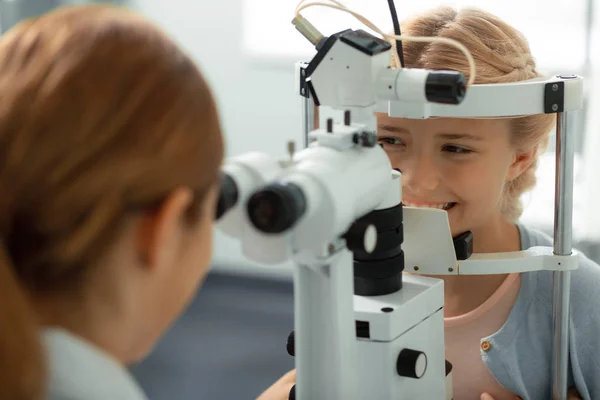 Menina sorrindo enquanto tendo consulta de visão ocular — Fotografia de Stock