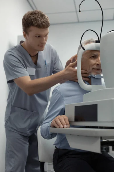 Brunetka okulista asystent stojący w pobliżu pacjenta — Zdjęcie stockowe