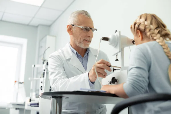 Médico de ojos envejecido de pelo gris con gafas consultora chica — Foto de Stock