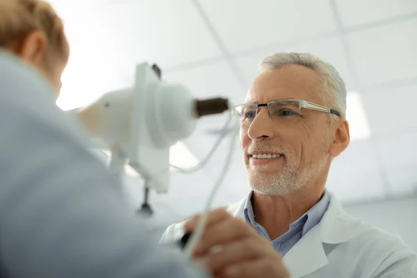 Médico de cabelos grisalhos barbudo usando óculos sorrindo — Fotografia de Stock